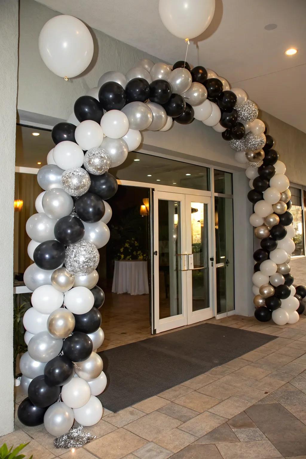 An elegant balloon garland in black, silver, and white.