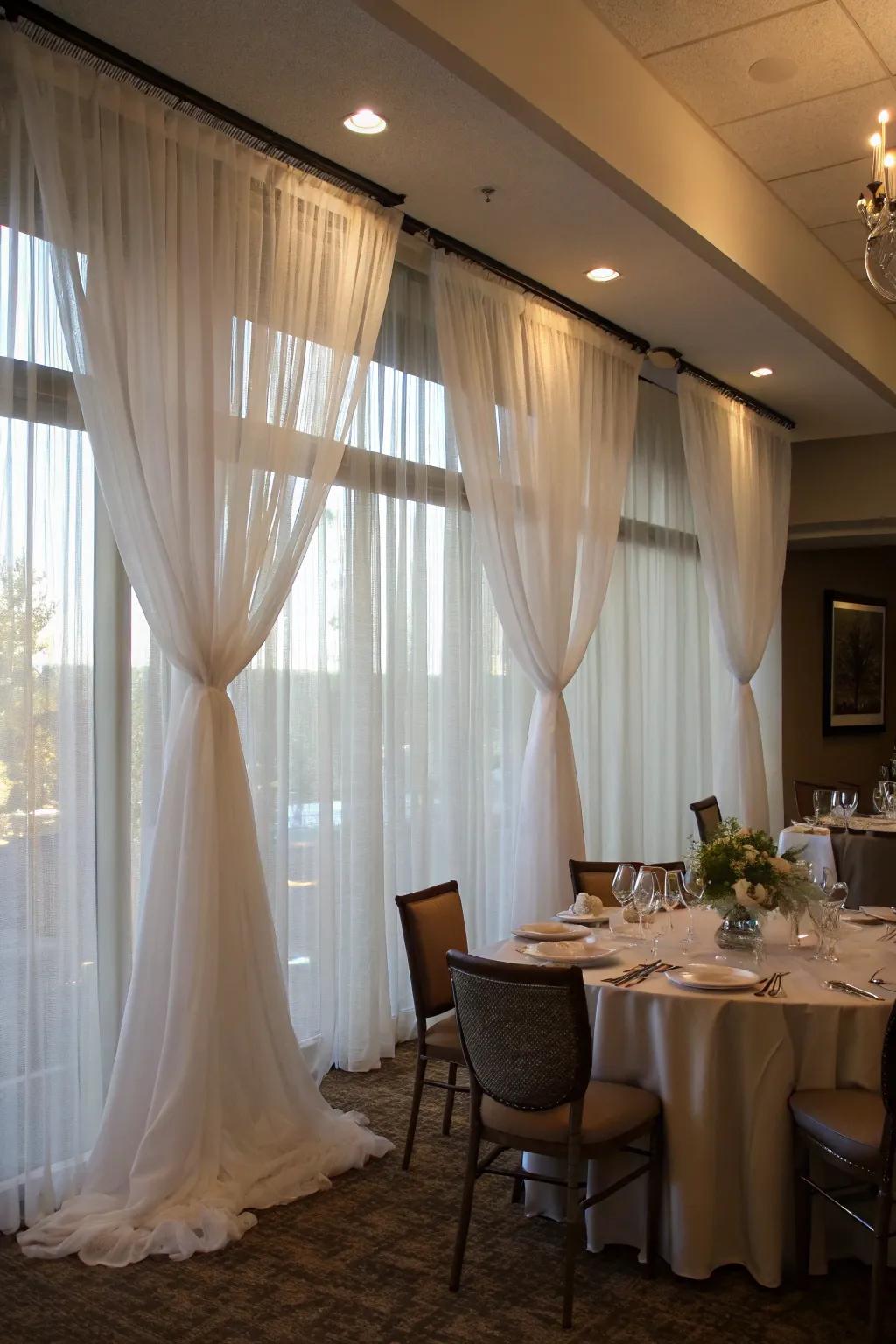 Sheer window coverings bring elegance to a movable wall in a dining area.