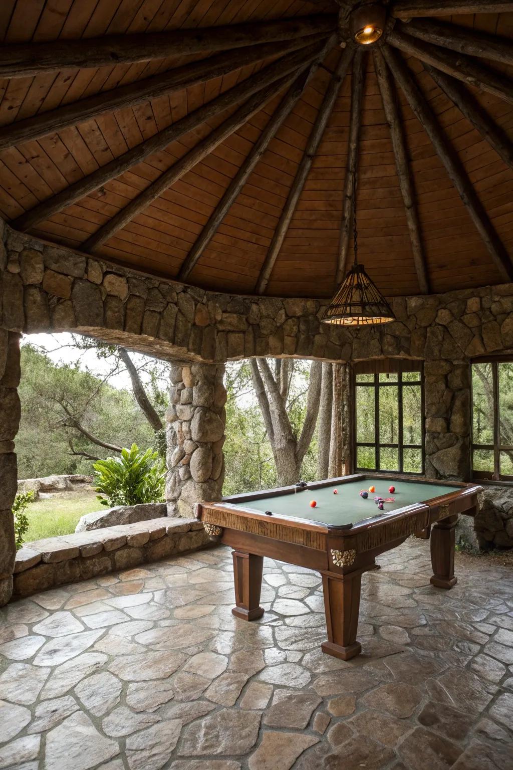 A rustic stone structure housing a pool table in a natural setting.
