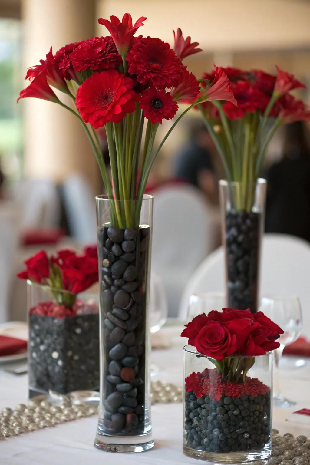 Containers of varying heights packed with scarlet blossoms and ebony pebbles for depth.