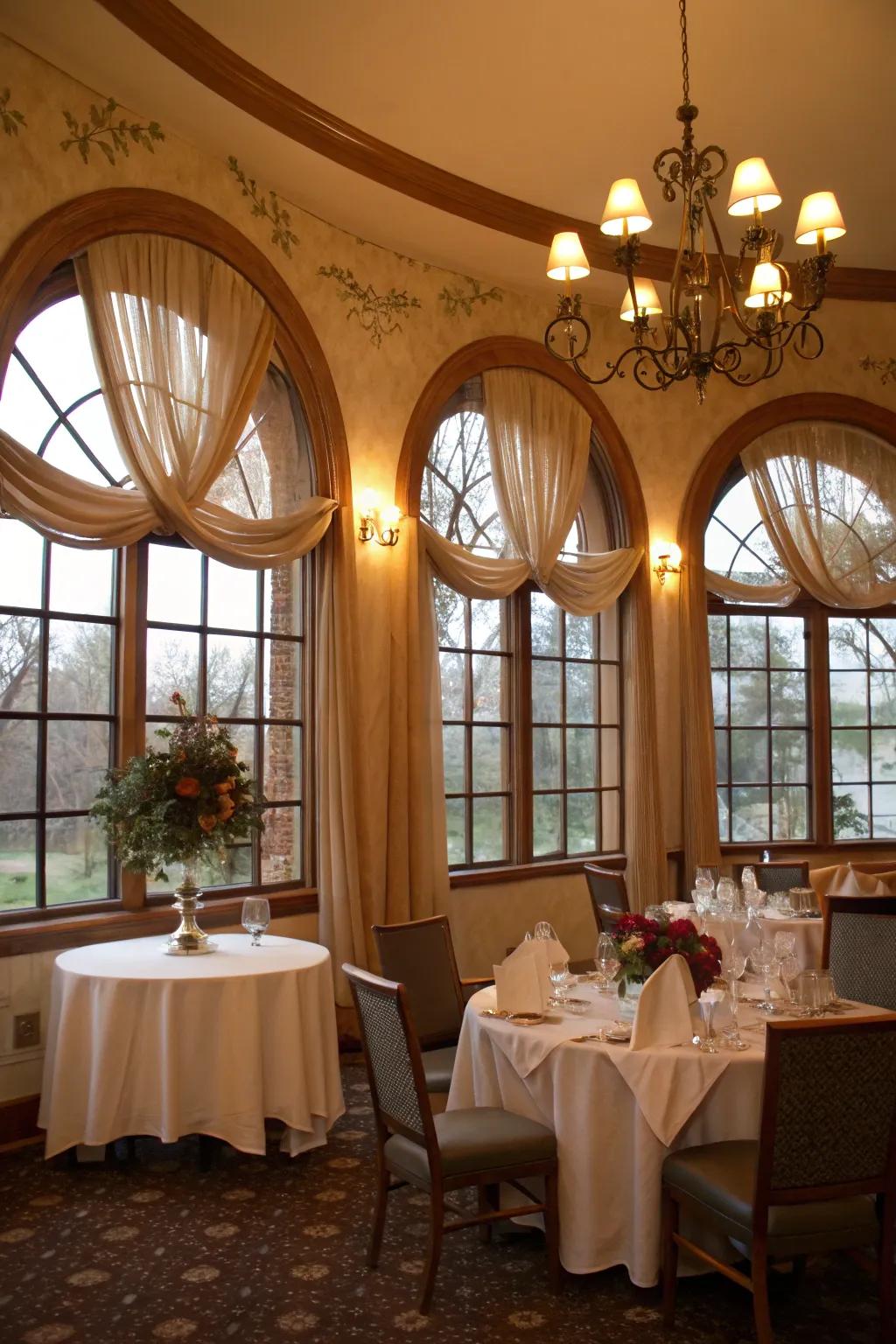 Romantic dining room with fabric swags on arched windows.