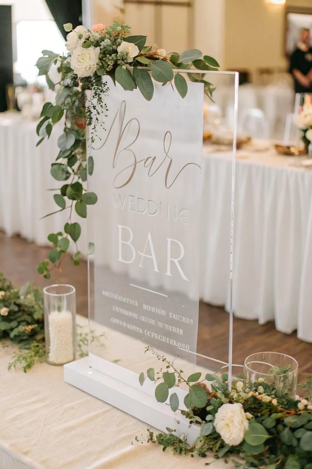 A sophisticated clear bar sign with modern lettering and greenery.