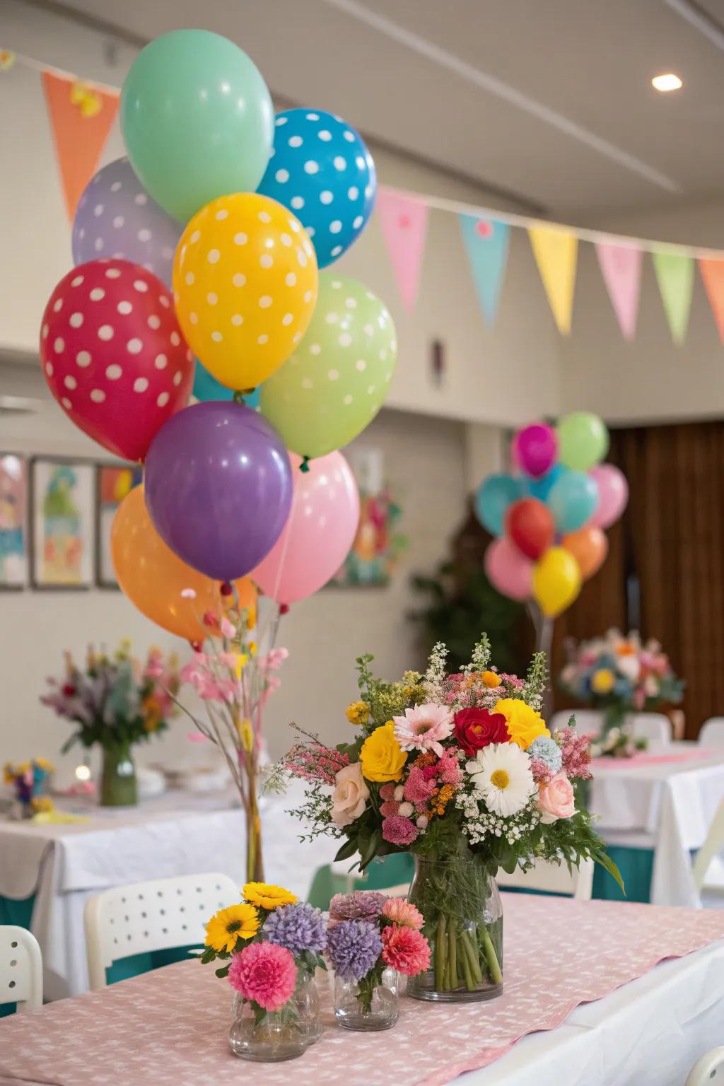 A celebratory table adorned with balloon bouquets and matching floral centerpieces.