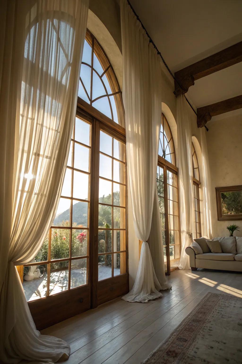 Sunlit room with sheer curtains on arched windows.
