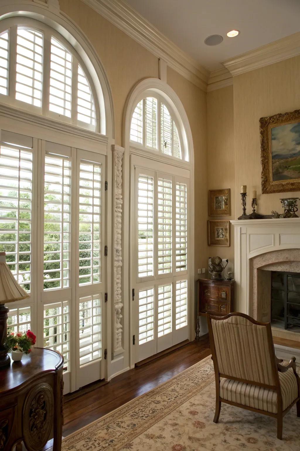 Traditional room with plantation shutters on arched windows.