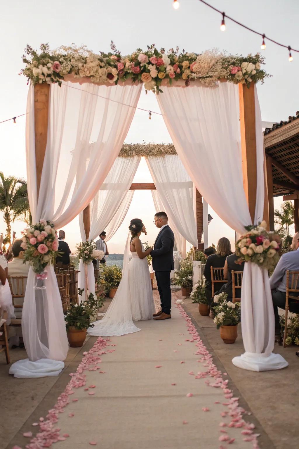 Romantic canopy drapes framing a wedding ceremony.