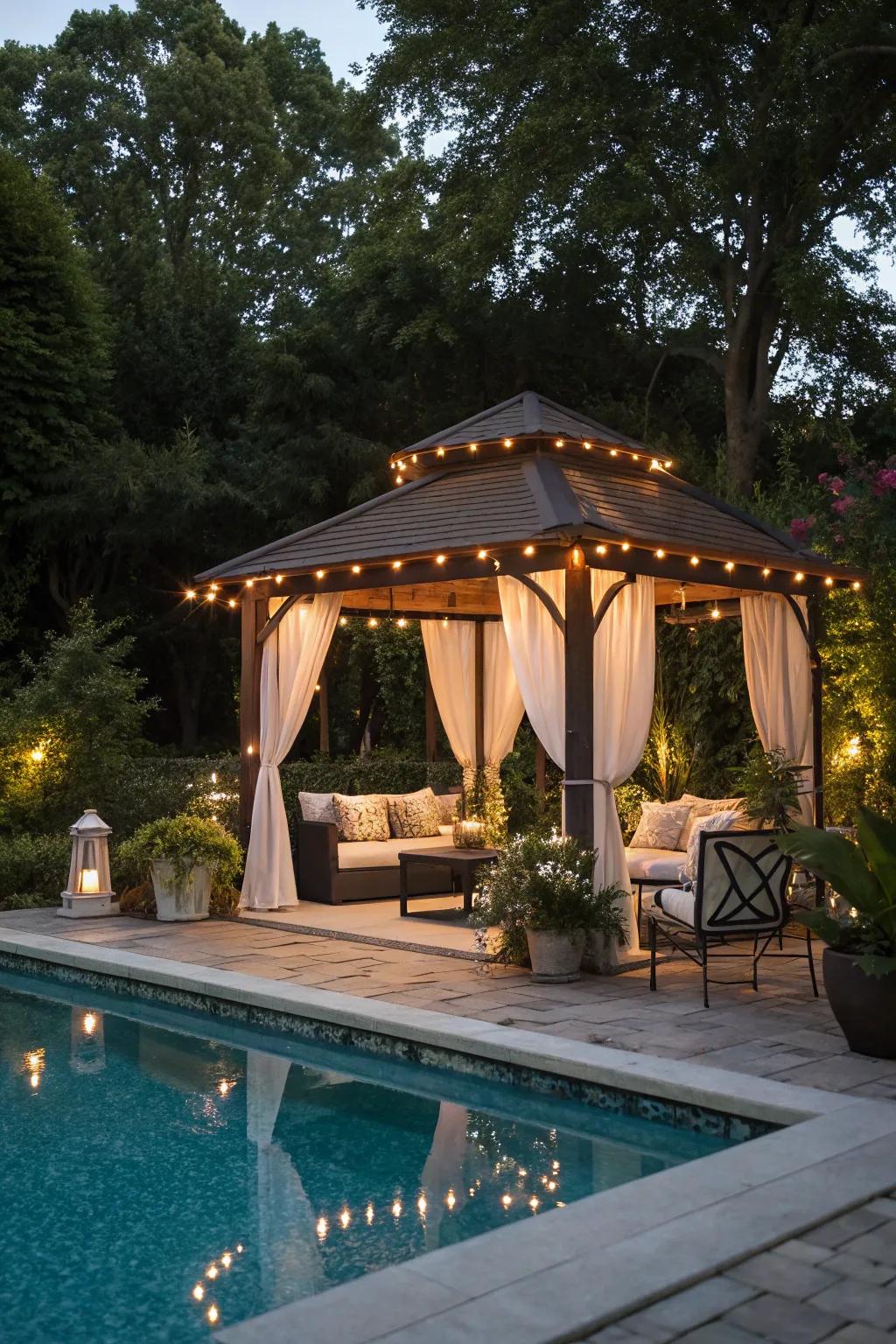 Canopy lighting in a gazebo crafts an intimate gathering spot by the pool.