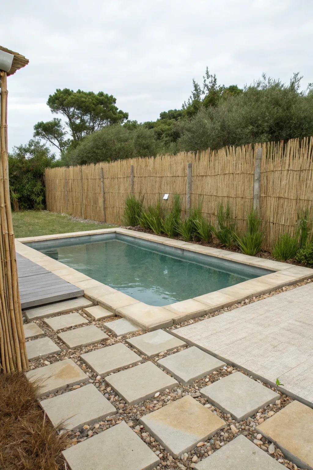 A thatch fence creating a serene, beachy atmosphere by the pool.