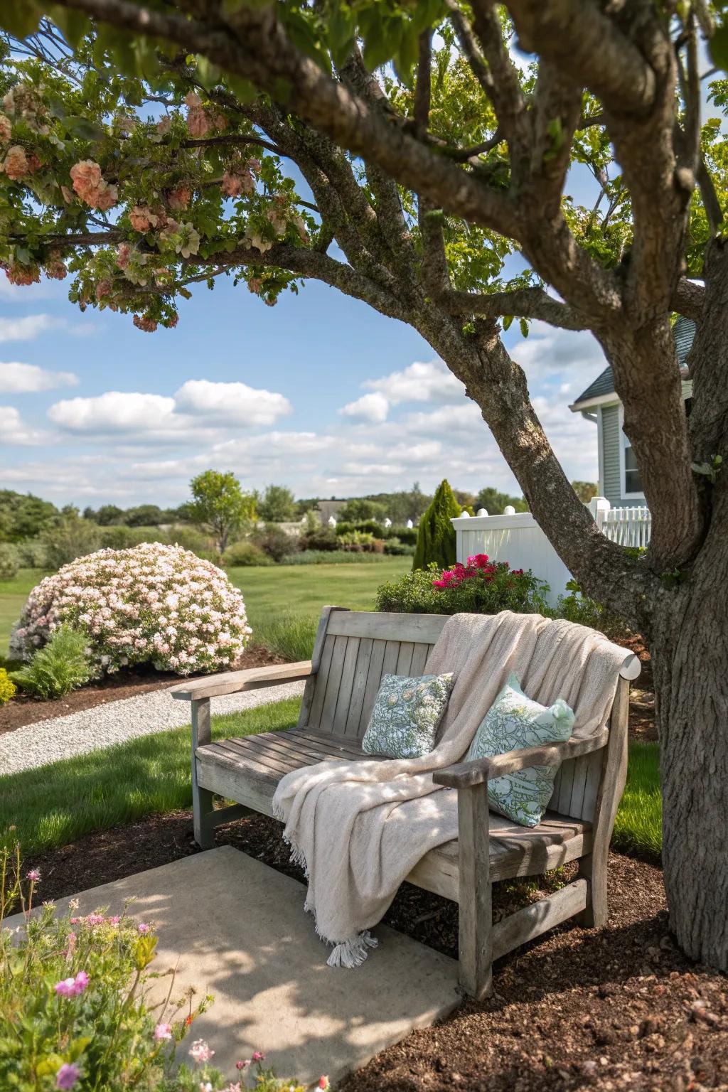 A seating space offers a soothing spot beneath the shade of a tree.
