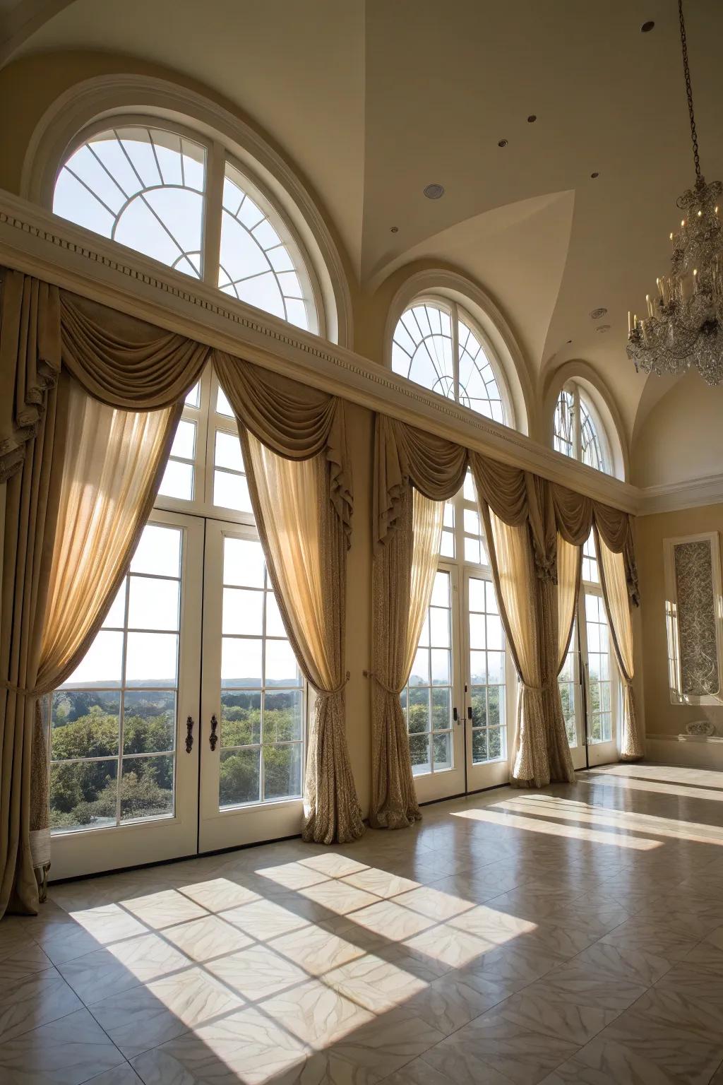Grand living space with ceiling-mounted drapes on arched windows.