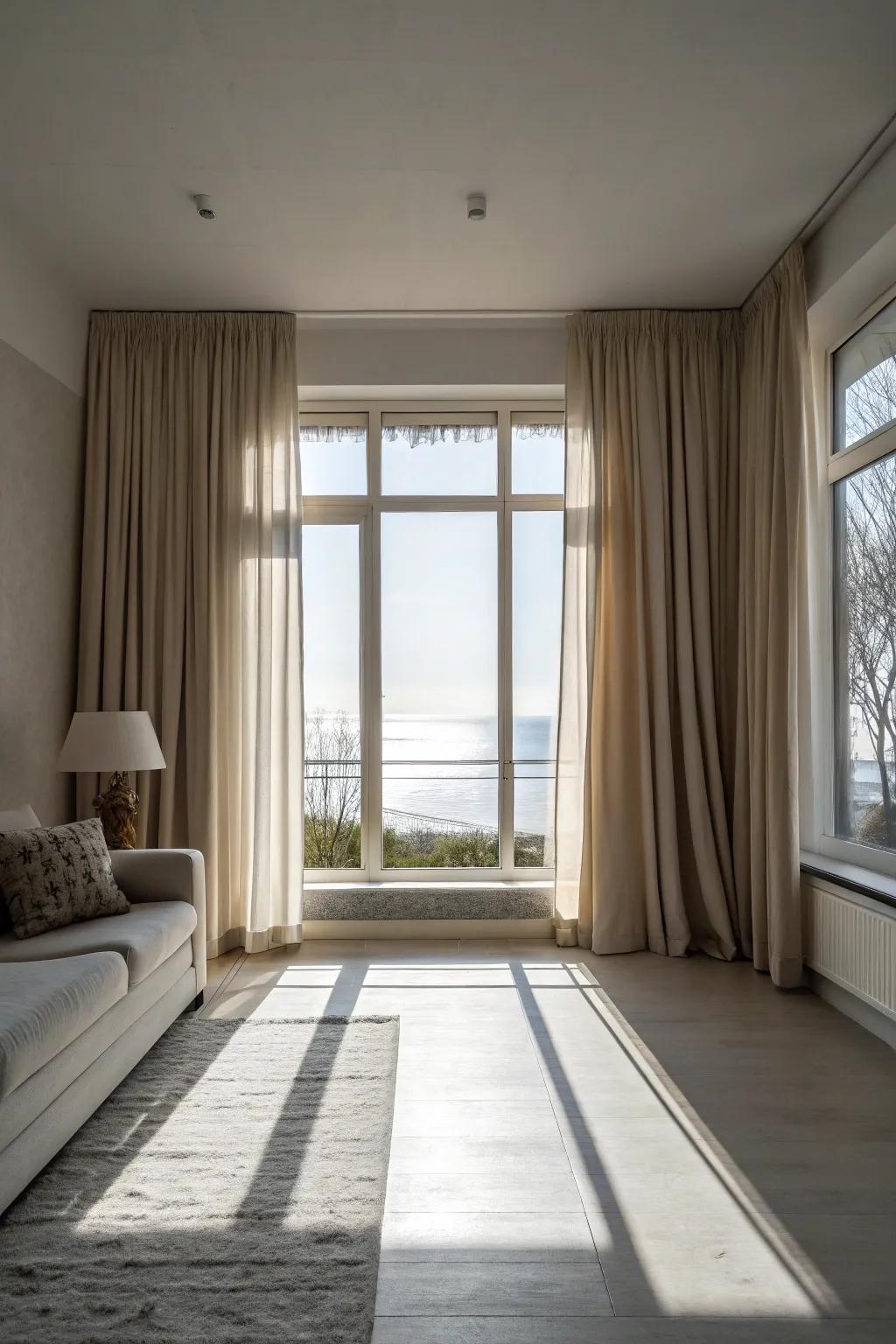 Minimalist living room with neutral tone curtains framing a picture window.