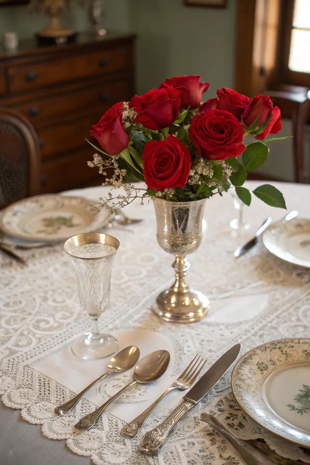 A vintage centerpiece with antique silverware and scarlet roses for classic elegance.