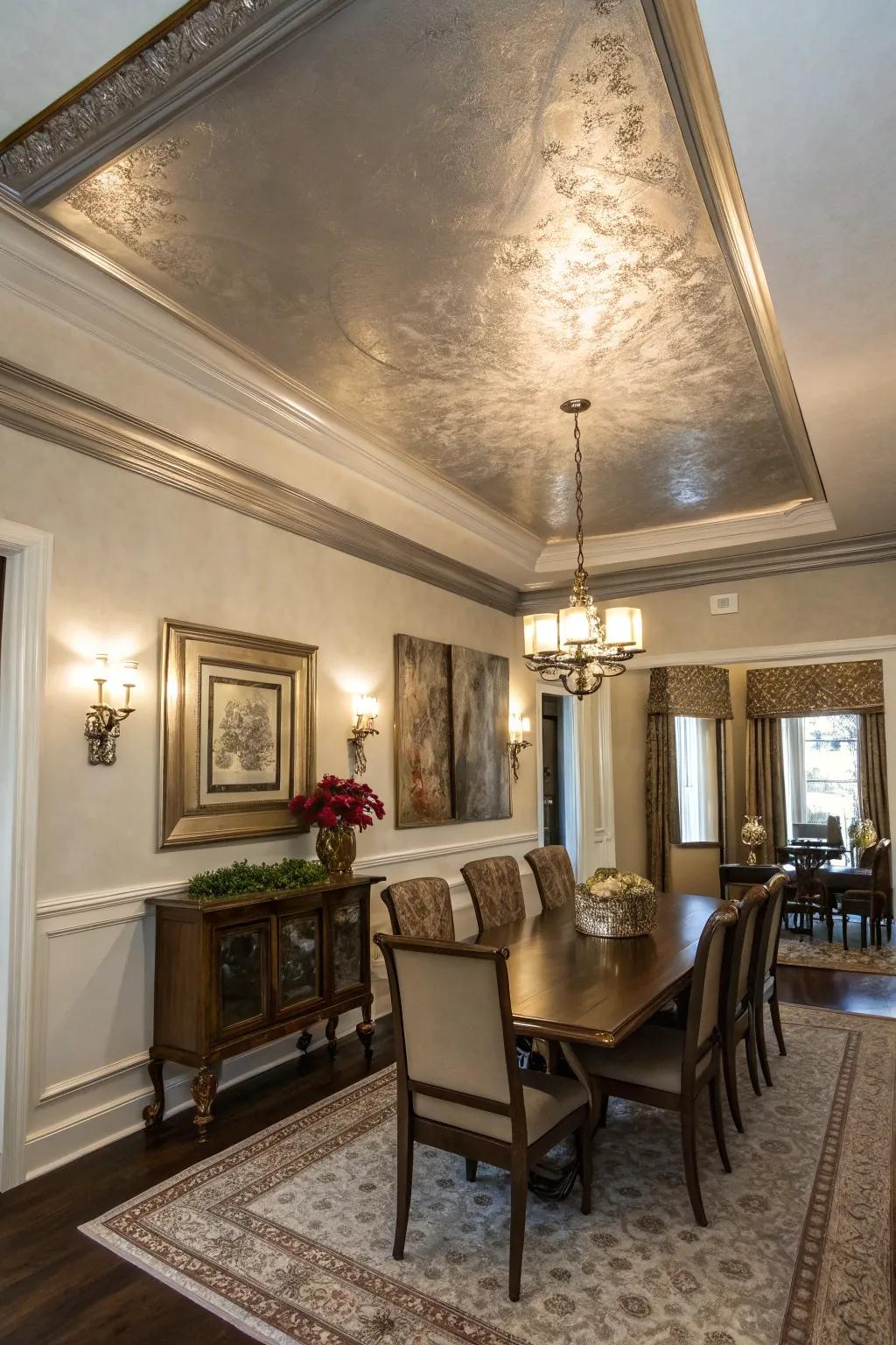A dining area featuring a tray ceiling with a glamorous metallic finish.