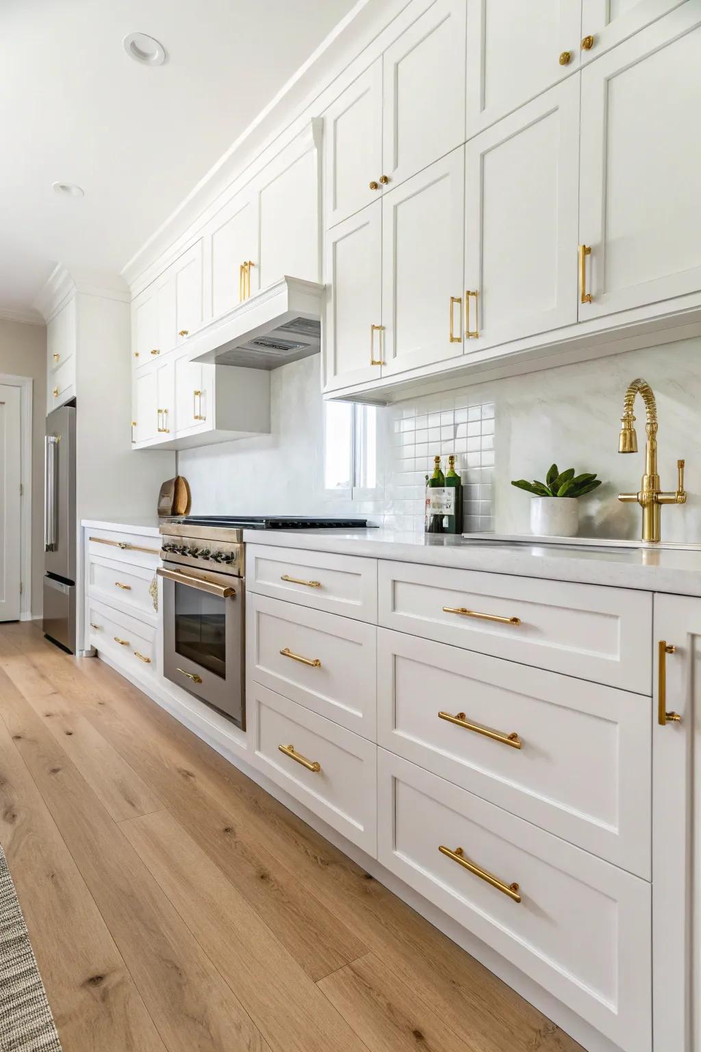 Opulent gilded accents elevating an ivory kitchen&rsquo;s elegance.